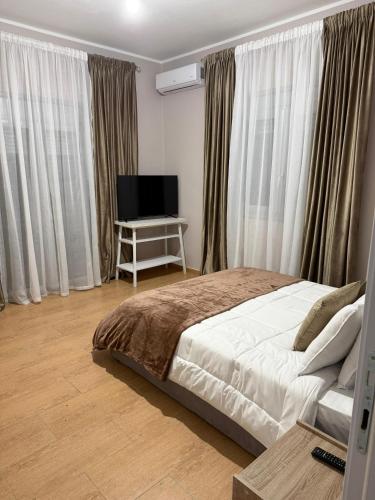 a bedroom with a bed and a flat screen tv at Villa Rusi in Shirgjan