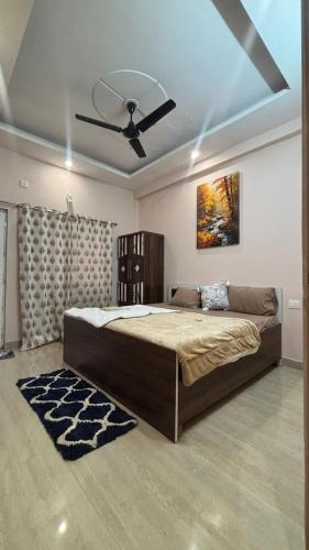 a bedroom with a large bed with a ceiling fan at Infinium Stay in Rishīkesh