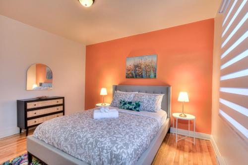 een slaapkamer met een bed met een oranje muur bij NDG & Montreal getaway in Montreal