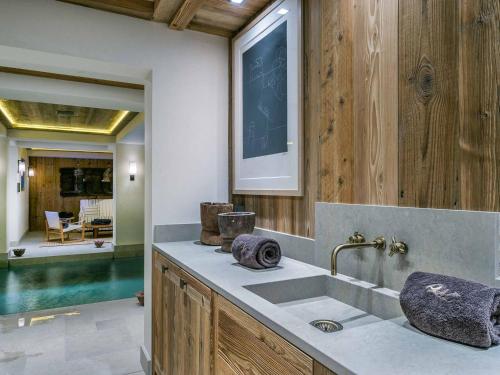 a bathroom with a sink and a mirror and a pool at Chalet raffiné avec chambres luxueuses et services inclus - FR-1-564-62 in Courchevel