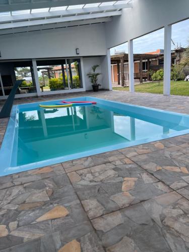 una piscina en medio de una casa con un patio de piedra en Hostal Lo de Mili, en Chuy