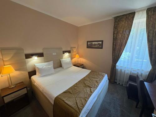 a hotel room with a large bed and a window at Hotel Leotar in Trebinje