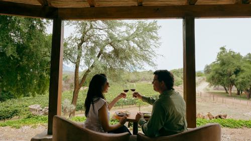 卡布拉科拉尔Sentio Camps的一对男女在门廊里喝酒