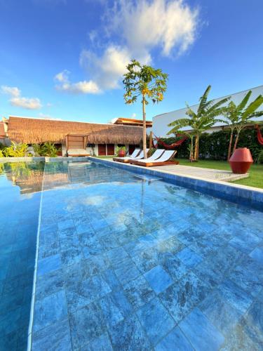 een zwembad met een resort op de achtergrond bij CACTUS CLUB - Hotel, Wellness Center & Spa in São Miguel do Gostoso