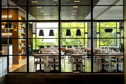 ein Restaurant mit Tischen und Stühlen und großen Fenstern in der Unterkunft Renaissance Seattle Hotel in Seattle