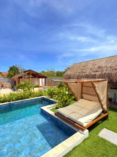 een bed naast een zwembad naast een huis bij CACTUS CLUB - Hotel, Wellness Center & Spa in São Miguel do Gostoso