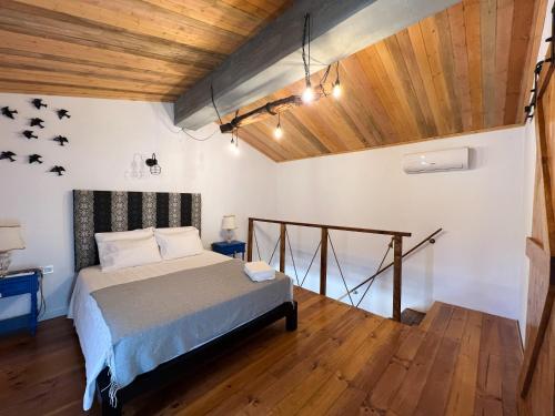 a bedroom with a bed and a wooden ceiling at JUNKEIRA - Casa, Douro e Campo in Junqueira