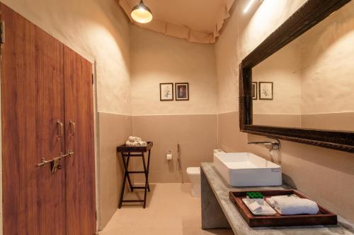 a bathroom with a sink and a mirror and a toilet at Tiger Machan in Sawāi Mādhopur
