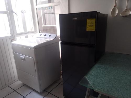 a kitchen with a black refrigerator and a stove at Amplía casa en Jardines Alcalde in Guadalajara