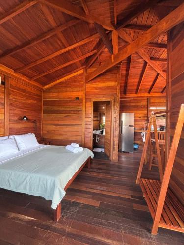 Canto do Mar - Atins - Lençóis Maranhenses في أتينز: غرفة نوم مع سرير في غرفة خشبية