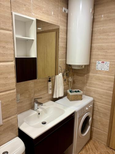 a bathroom with a sink and a washing machine at Luxury in Sveti Vlas