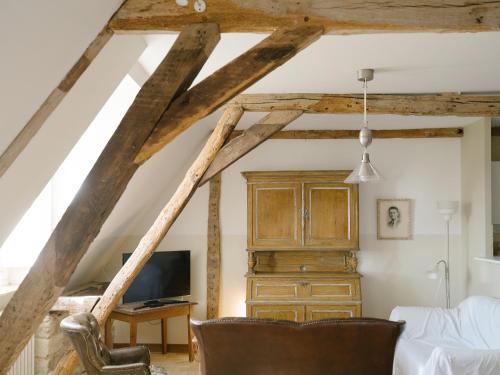 a room with wooden beams and a bed and a tv at Domaine de Kermadio in Pluneret