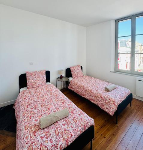 a bedroom with two beds and a window at Côté Aisne - vue imprenable in Soissons