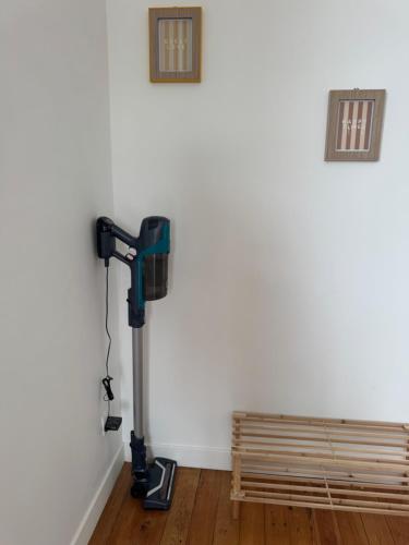 Una habitación con una aspiradora al lado de un banco de madera. en Côté Aisne - vue imprenable, en Soissons
