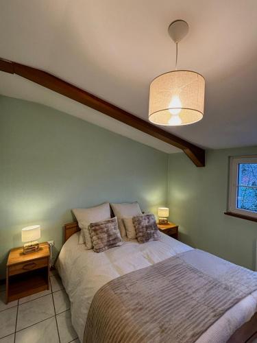 ein Schlafzimmer mit einem Bett mit zwei Nachttischen und zwei Lampen in der Unterkunft Domaine Wagenbourg à Soultzmatt in Soultzmatt