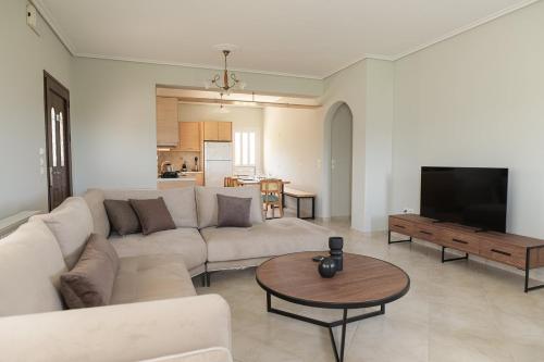 un soggiorno con un divano e un tavolo di Vasilopoulos Residences - Apartments Ioni & Neso, Eliana & Melanthia ad Argostoli