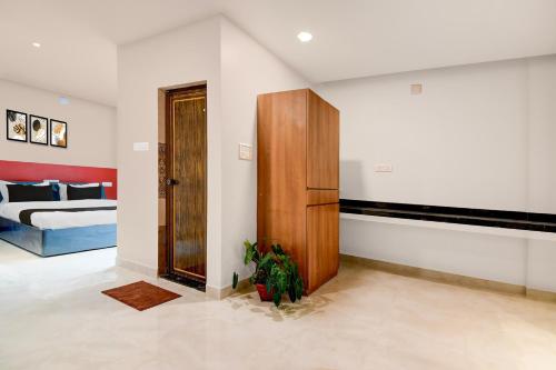 Habitación con puerta de madera y dormitorio en Super Hotel O Avigna Premium, en Bhubaneshwar