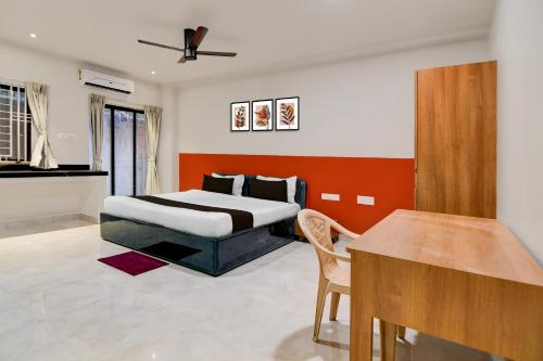 Un dormitorio con una cama y una mesa dentro. en Super Hotel O Avigna Premium, en Bhubaneshwar