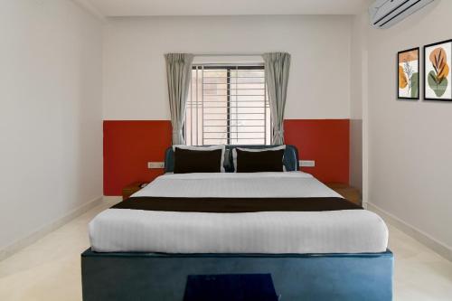 a bedroom with a large bed in front of a window at Hotel O Infocity Square Road Bhubaneswar Formerly Avigna Premium in Bhubaneshwar