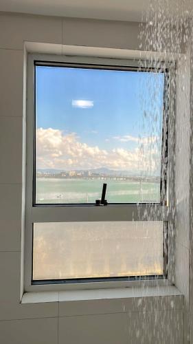 a shower with a window with a view of the ocean at Iate Hotel Centro Florianópolis by RB Hotelaria in Florianópolis