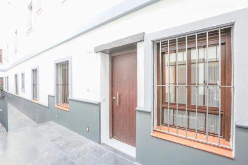 un pasillo con puertas y ventanas en un edificio en Plaza de Armas Apartment, en Sevilla