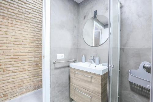 un baño con lavabo y espejo en Plaza de Armas Apartment, en Sevilla