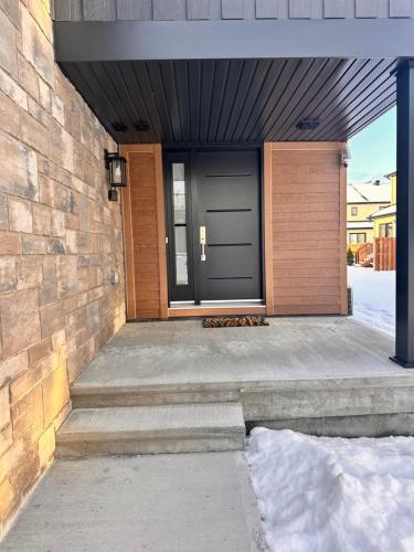 eine Eingangstür eines Hauses mit einer Ziegelwand in der Unterkunft Cozy and Spacious Suite in a Pet and Smoke free Home - Self checkin Anytime - Private Ensuit Bath - King Bed - Ultra Fast Wifi - Free Parking - Smart TV in Rockland