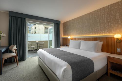 Sonesta Hotel Miraflores في ليما: غرفة فندقية مع سرير كبير وشرفة