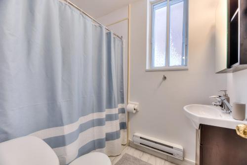 een badkamer met een douchegordijn en een wastafel bij NDG & Montreal getaway in Montreal