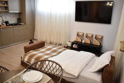 a room with a bed and a table and a tv at Aba Fly & Rest in Otopeni