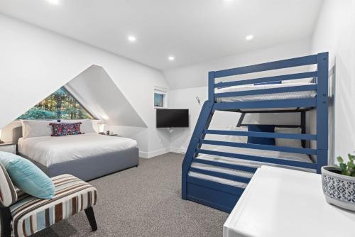 a bedroom with a blue bunk bed and a couch at Modern Home with Forested Views by Harmony Whistler in Whistler