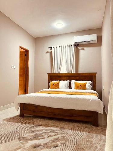 a bedroom with a large bed with yellow pillows at Manzi Hub Residence in Zanzibar City
