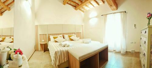 ein Schlafzimmer mit einem Bett mit weißen Laken und einem Fenster in der Unterkunft Locanda la Rocca Residenza d'Epoca in Fossombrone