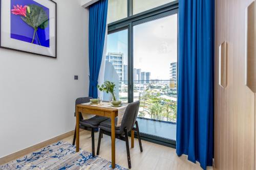 a dining room with a table and a large window at Roomook Apartments in Dubai