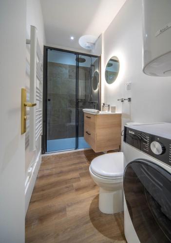 a bathroom with a toilet and a sink and a shower at Place Carnot in Tournus