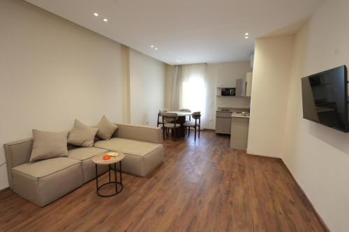ein Wohnzimmer mit Sofa und Tisch in der Unterkunft Settle Inn Banafseg Apartments in Kairo