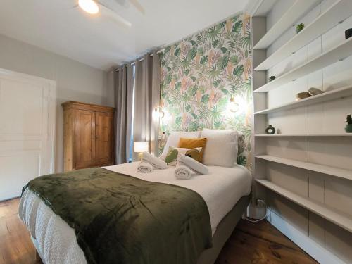 a bedroom with a bed with a floral wall at Splendid T4 - Spacious - Air conditioning - 6 People in Pau