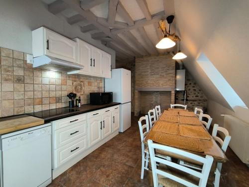 a kitchen with white cabinets and a table and chairs at Splendid T4 - Spacious - Air conditioning - 6 People in Pau