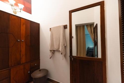 a bathroom with a wooden cabinet and a mirror at Retreat by Hexa 4 Bedroom with pool and Event Space in Trivandrum