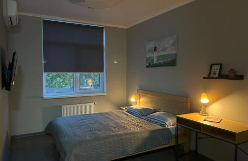 a bedroom with a bed and a window with a lighthouse at Comfort in Chernihiv