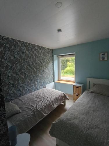 een slaapkamer met twee bedden en een raam bij Les Reflets de Meuse in Revin