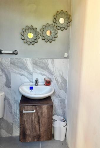 a bathroom with a sink and some flowers on the wall at Casa finca platanales in Cartagena de Indias