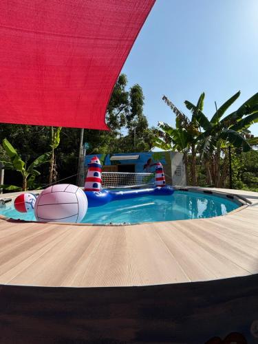 una gran piscina con una sombrilla roja. en Casa finca platanales, en Cartagena de Indias