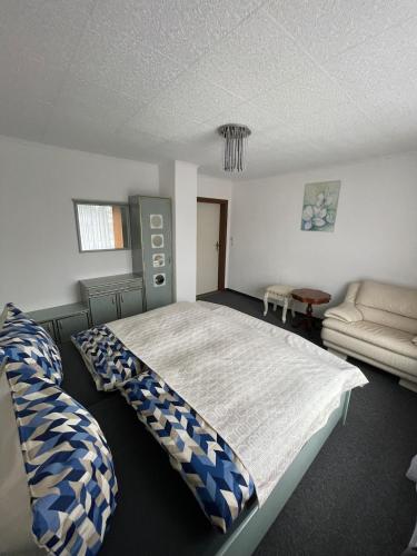 a bedroom with a large bed and a couch at Nussknackerstube in Seiffen