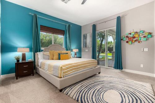 a bedroom with blue walls and a bed and a window at Sunny Daze in Old Town Scottsdale - Heated Pool in Scottsdale