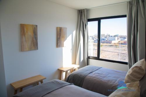 a bedroom with a bed and a window with a view at Neuquen Riverside in Neuquén