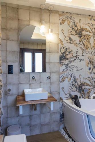 a bathroom with a bath tub and a sink at Portal Fosc Suites in Peniscola