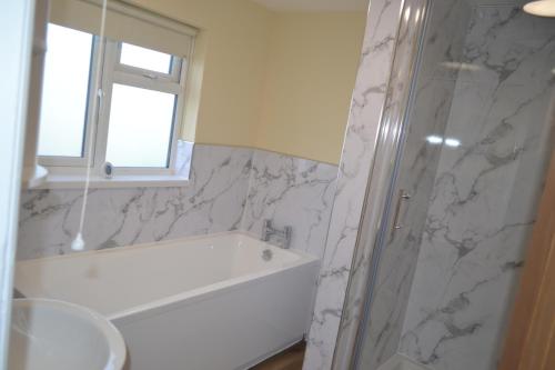 a white bathroom with a tub and a sink at Royal Oak Apartment in Brewood