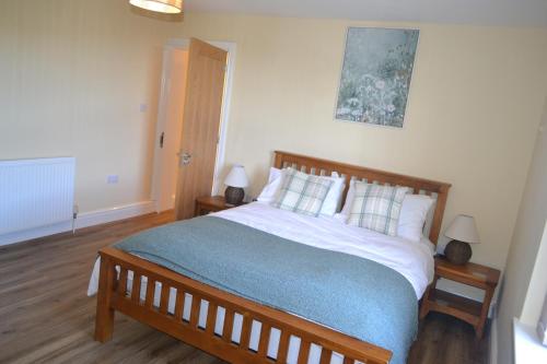 a bedroom with a large bed with a blue blanket at Royal Oak Apartment in Brewood