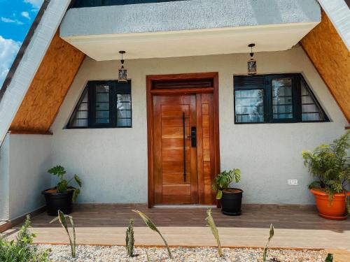 Le Satima Farmhouse في Nyahururu: باب أمام منزل به نباتات الفخار